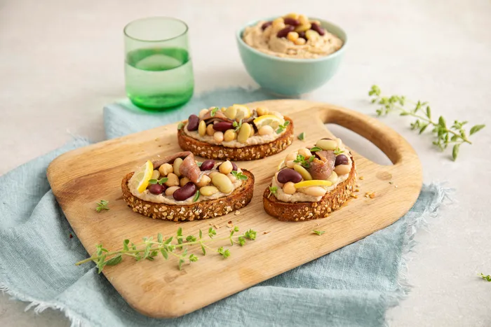 Bruschette con mix di legumi, acciughe e limone