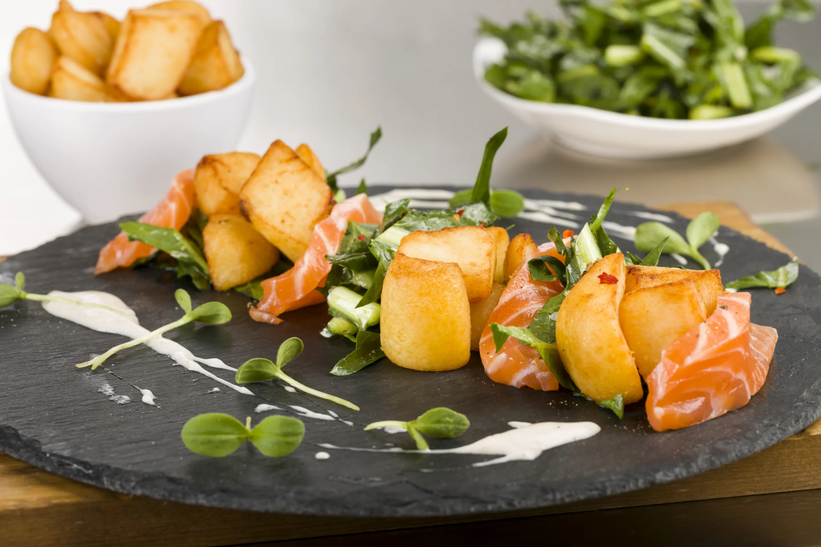 Insalata calda di patate rustiche arrostite con darne di salmone, cicorielle all'aglio e peperoncino e panna acida