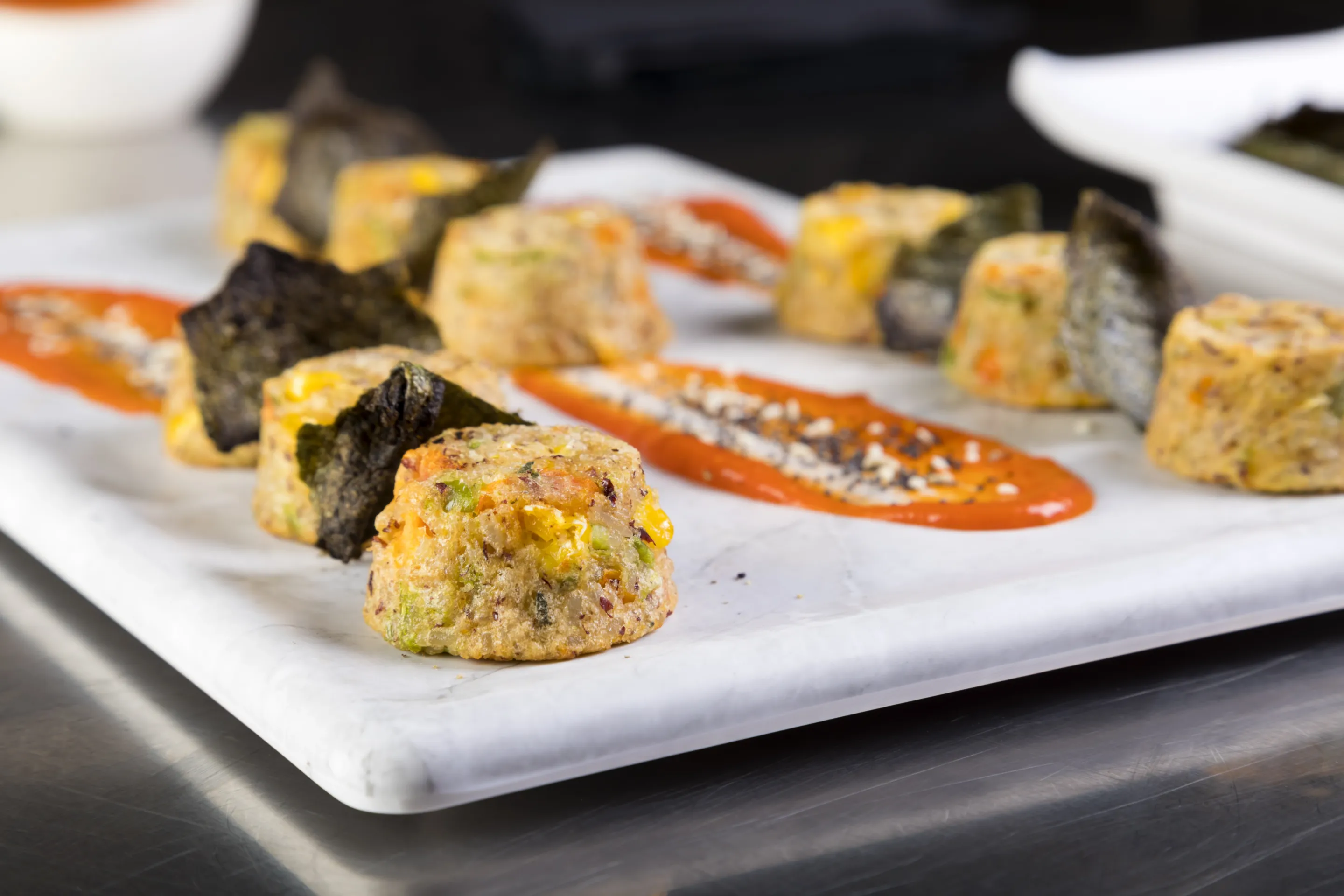 Snack basmati, verdure e cheddar su salsa piccante e chips di alga nori