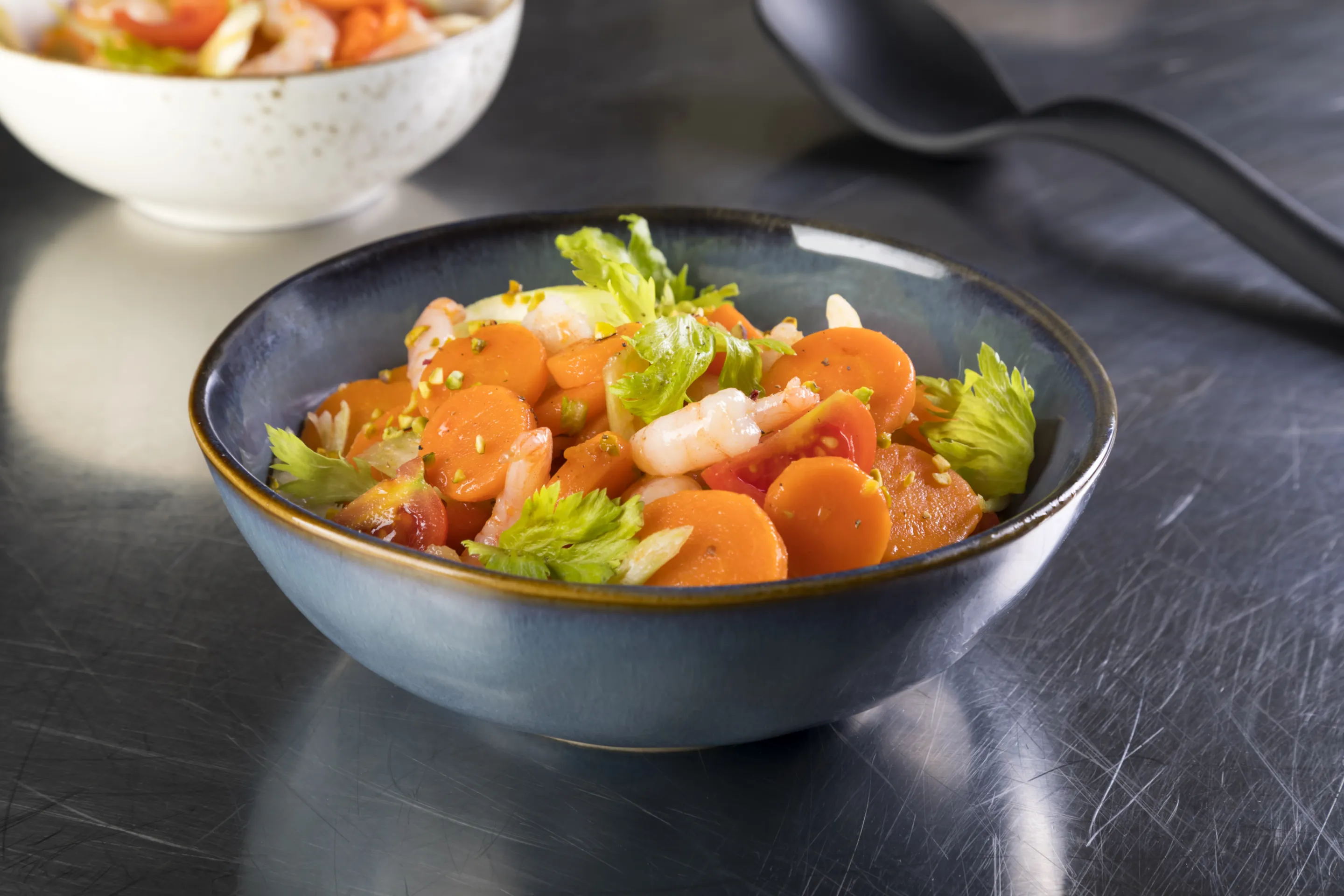 Insalata di carote a rondelle con code di gamberi, sedano, pomodoro e pistacchi