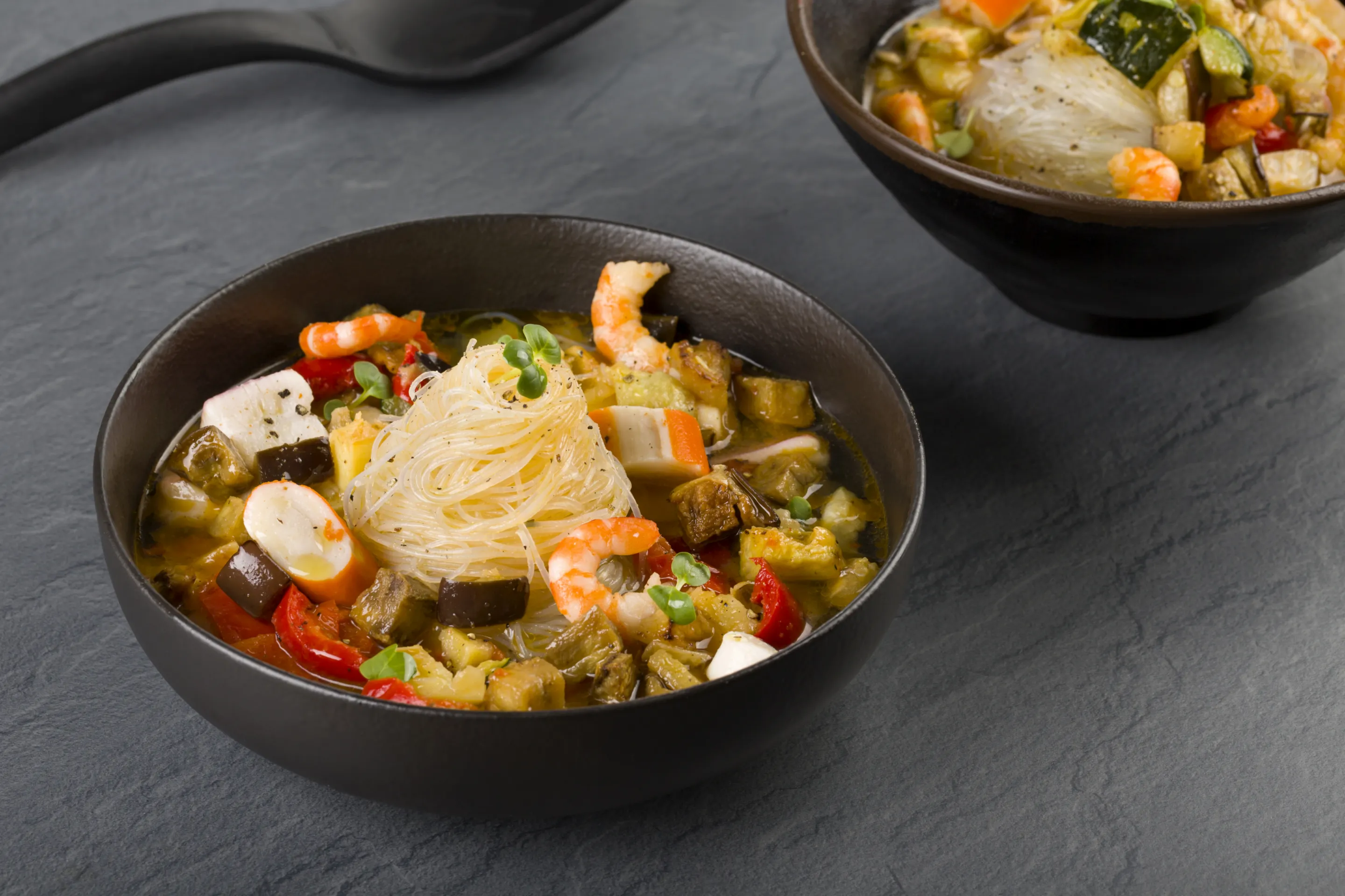 Spaghetti di riso in brodo con fantasia mediterranea e misto frutti di mare