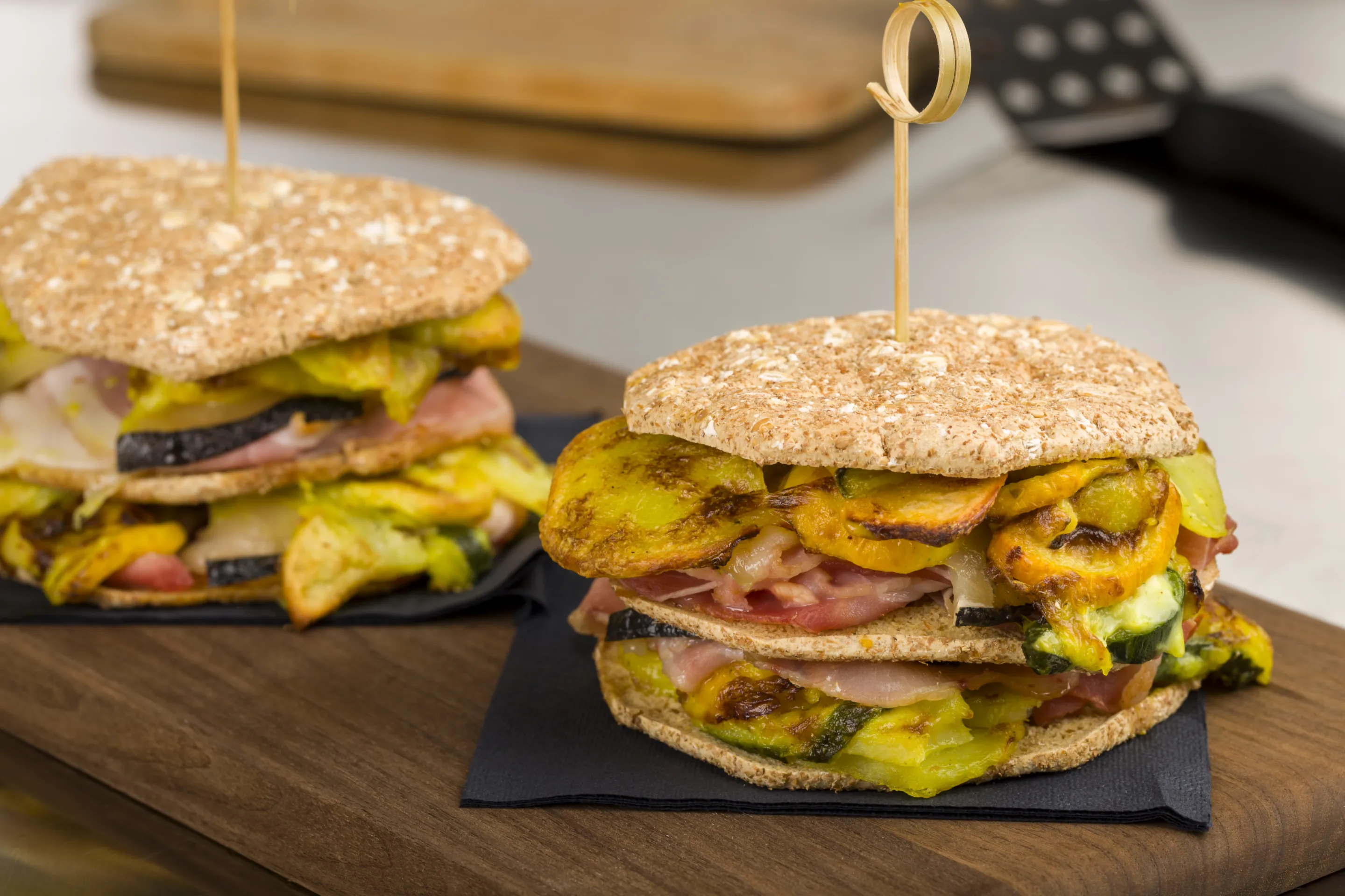 Crispy cereal burger con gratin di zucchine e patate, bacon e formaggio