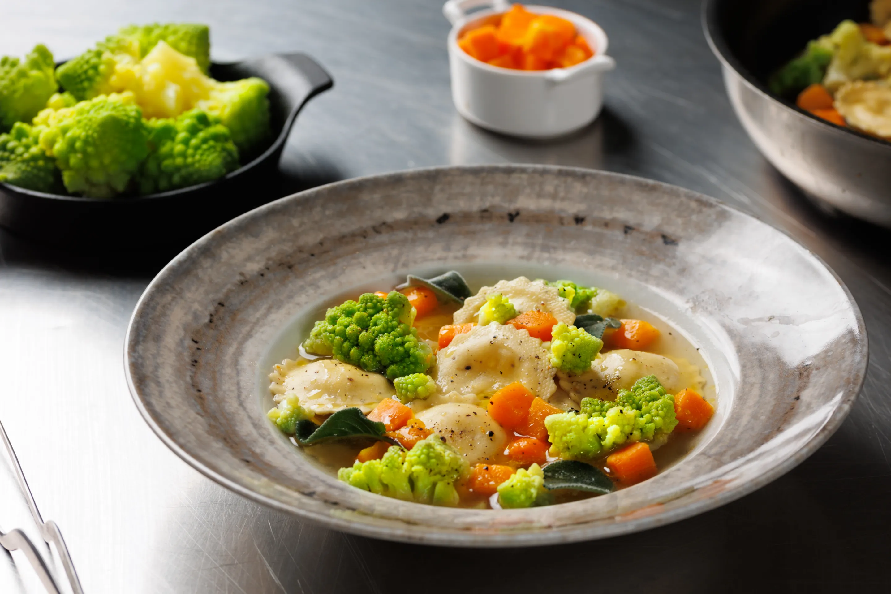 Ravioli con zucca e cavolo romanesco, brodo leggero e salvia