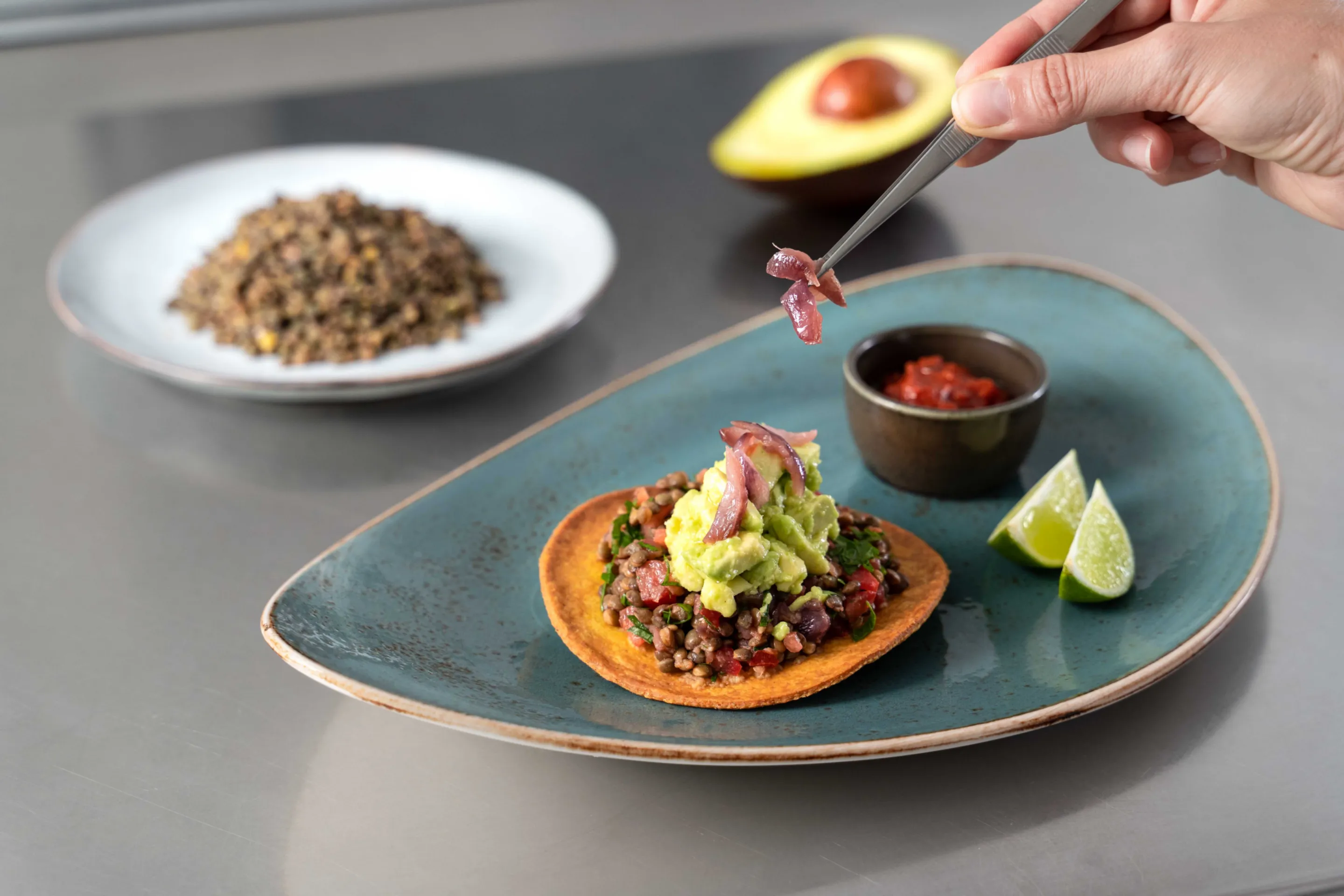 Ceviche di lenticchie con pomodori, cipolla rossa grigliata, prezzemolo, lime, tostada di mais e guacamole leggera