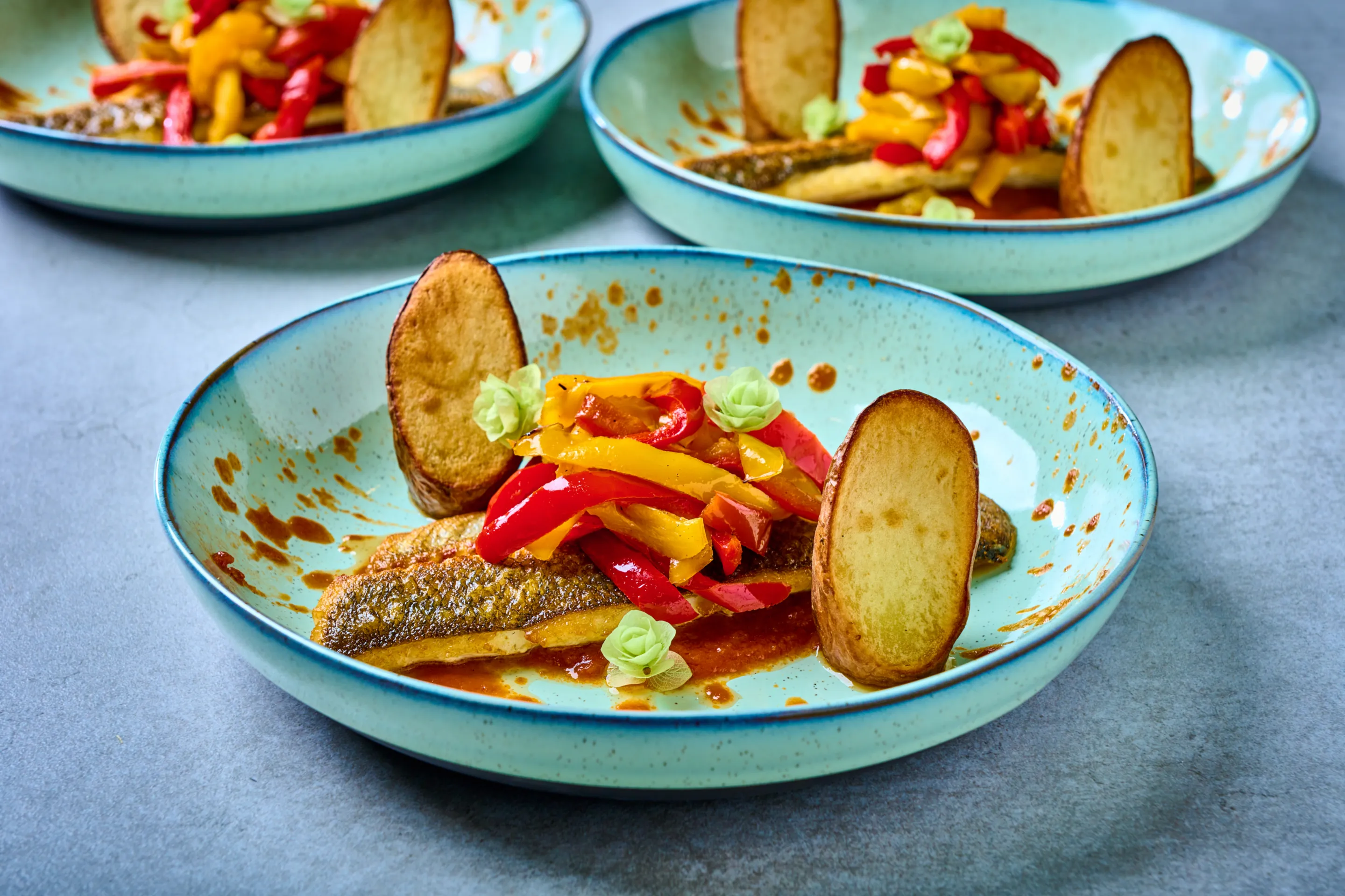 Zeebaars gegaard op tomatencompote met gegrilde paprika