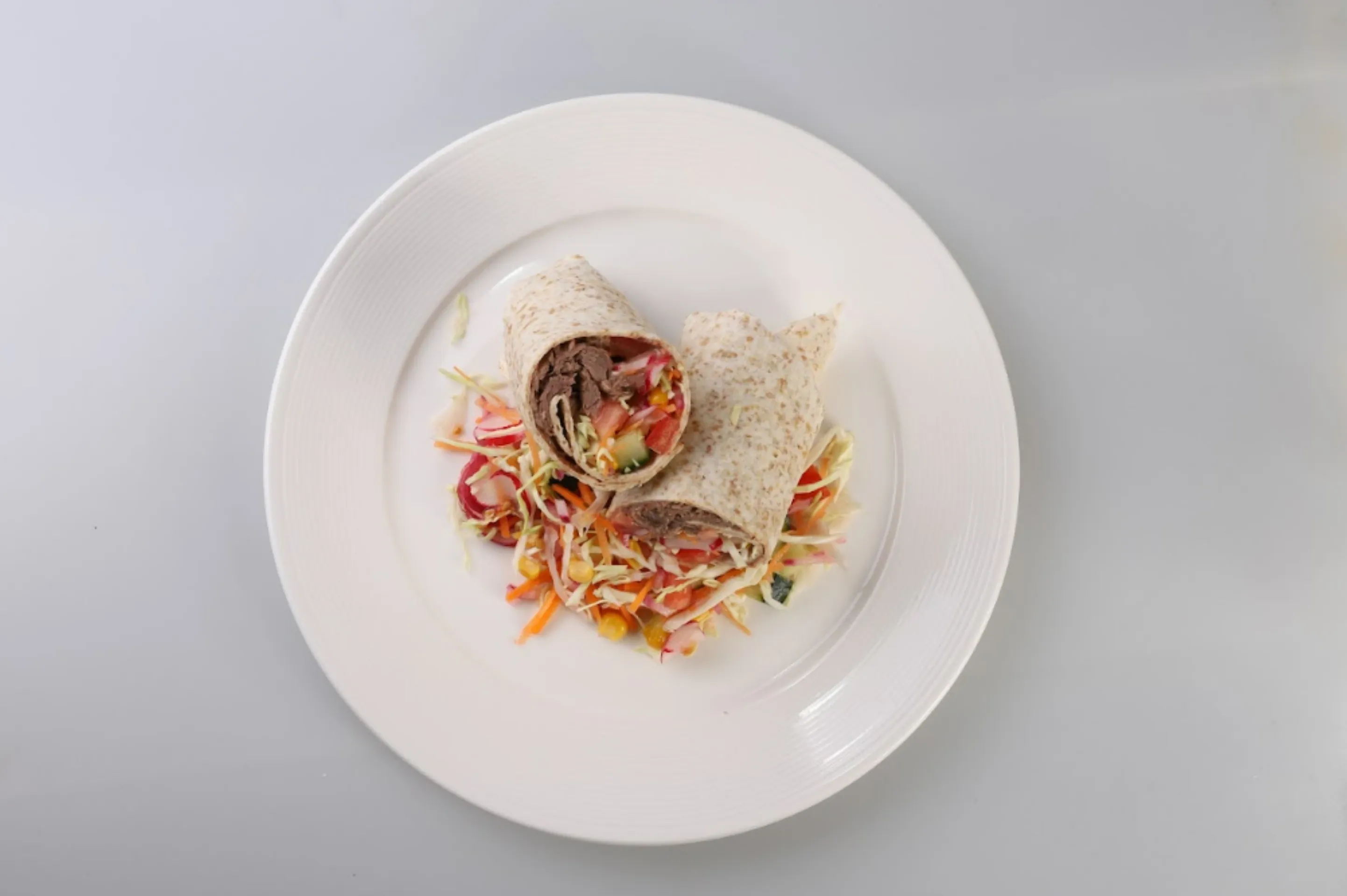 Tortilla plněná trhaným masem, zeleninou a fazolovým dresingem